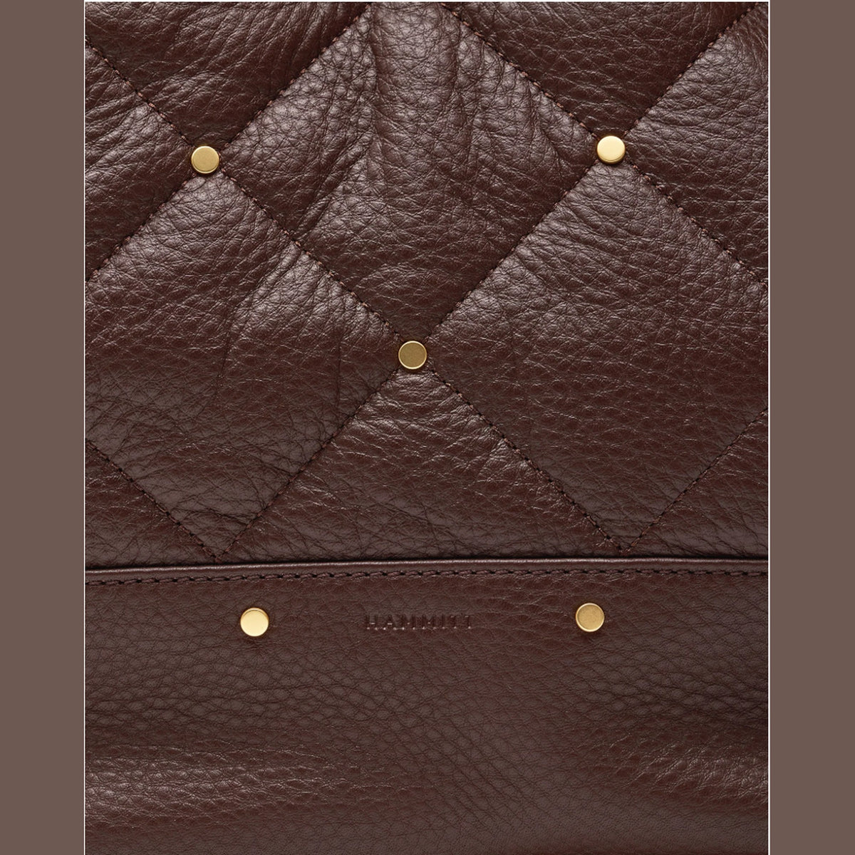 Close-up of quilted espresso leather with mini rivets